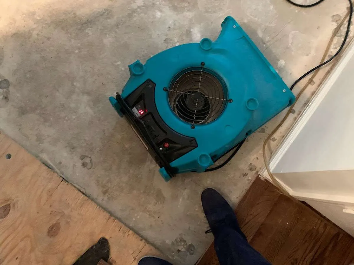 Air mover drying subfloor during Commercial Water Damage Restoration in Laconia